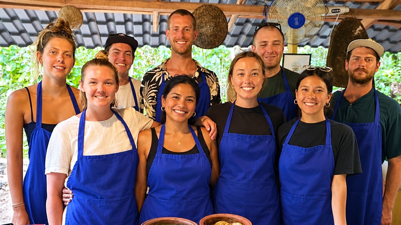 Guest in a blue blouse preparing Sri Lankan food at an outdoor cookery class in Ella